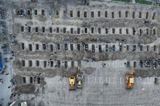 In this aerial handout picture released by the Iranian Press Center, mourners dig graves during the funeral for children killed in a reported strike on a primary school in Iran's Hormozgan province in Minab on March 3, 2026